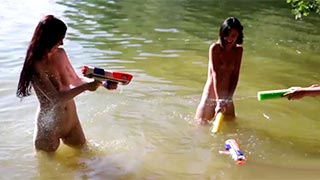 Tres jóvenes modelos juegan en el lago completamente encueradas